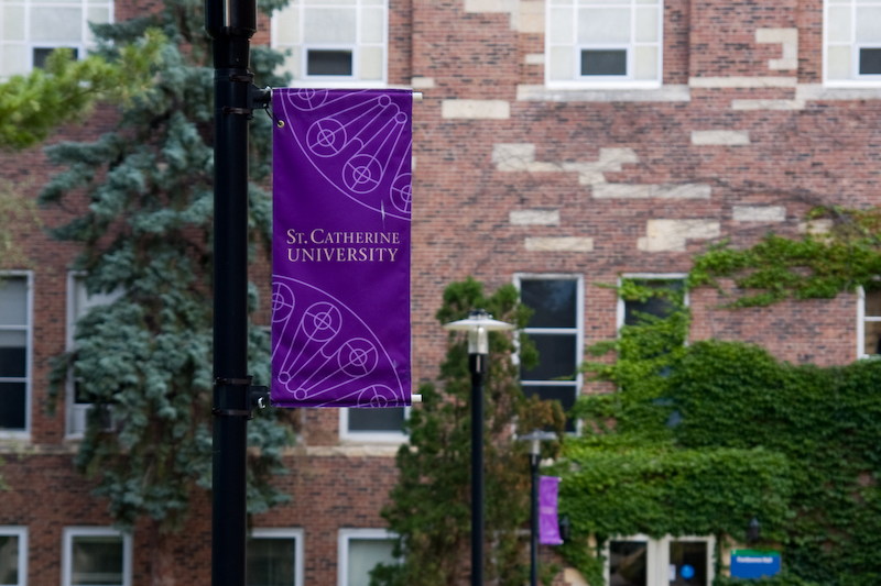 St. Catherine University flag in front of brick campus building