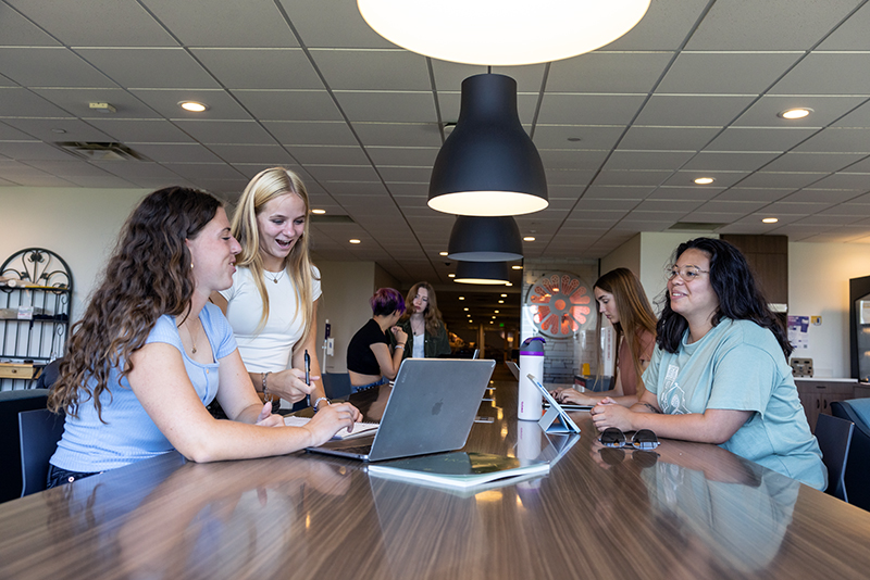 female students studying together at a table in lounge