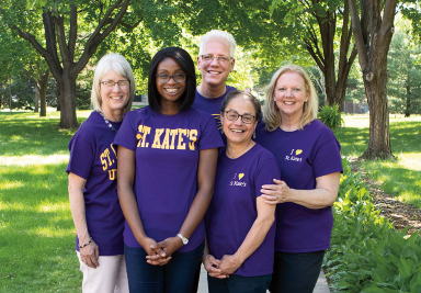 Group of five St. Kate's employees proudly sport St. Kate's t-shirts