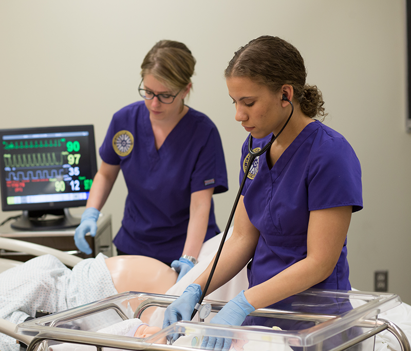 two nursing students working in simulation class