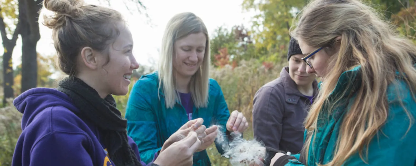 photo of 4 St. Kate's students volunteering in a field at Citizen Katie