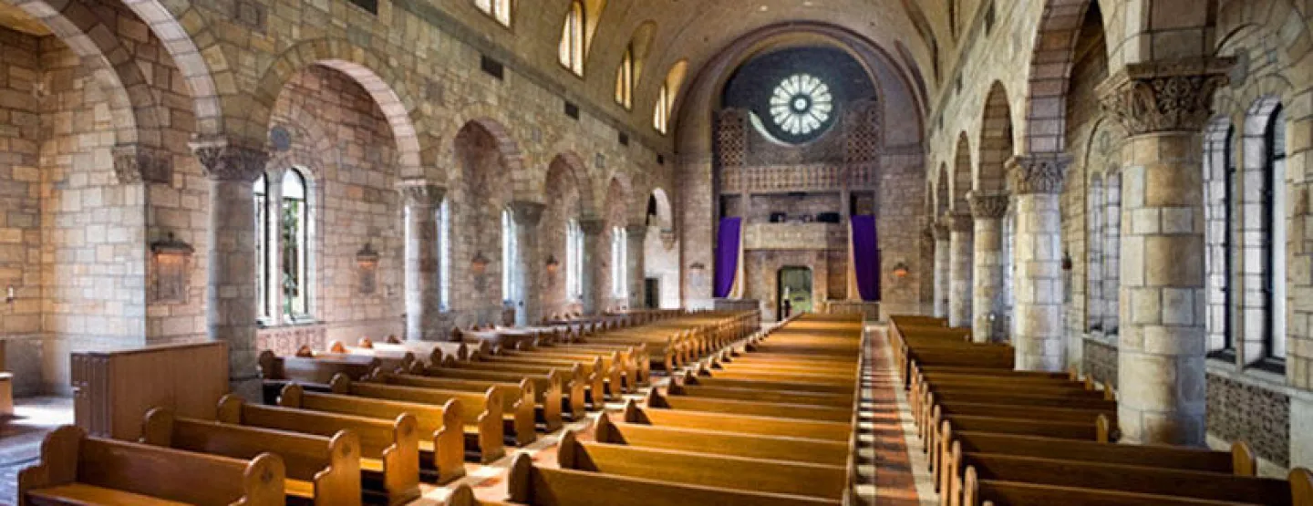 view of Our Lady of Victory Chapel from the back, facing the Rose Window over the pews